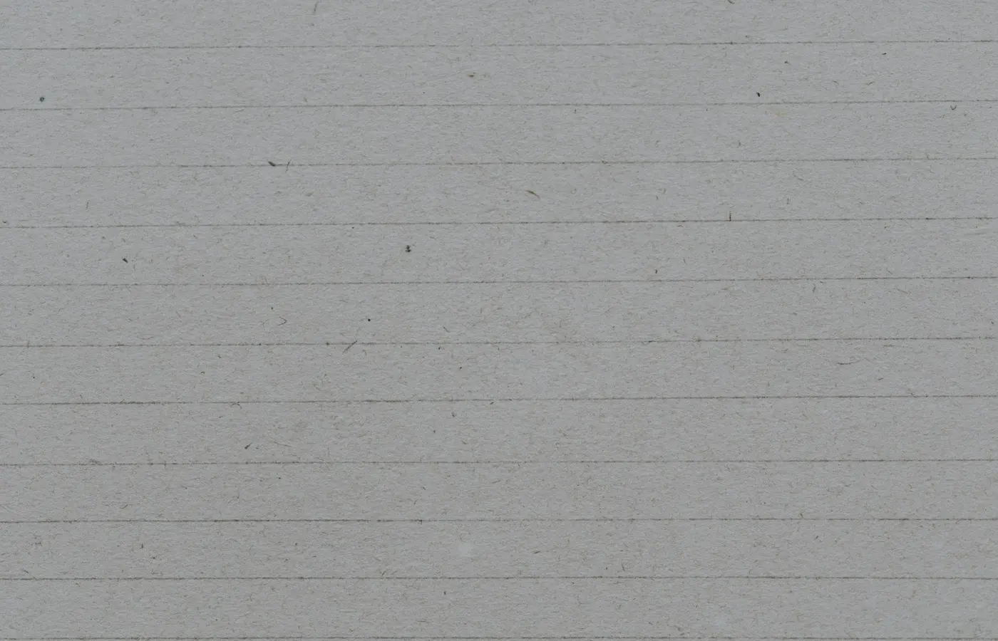 a black and white cat sitting on a piece of lined paper